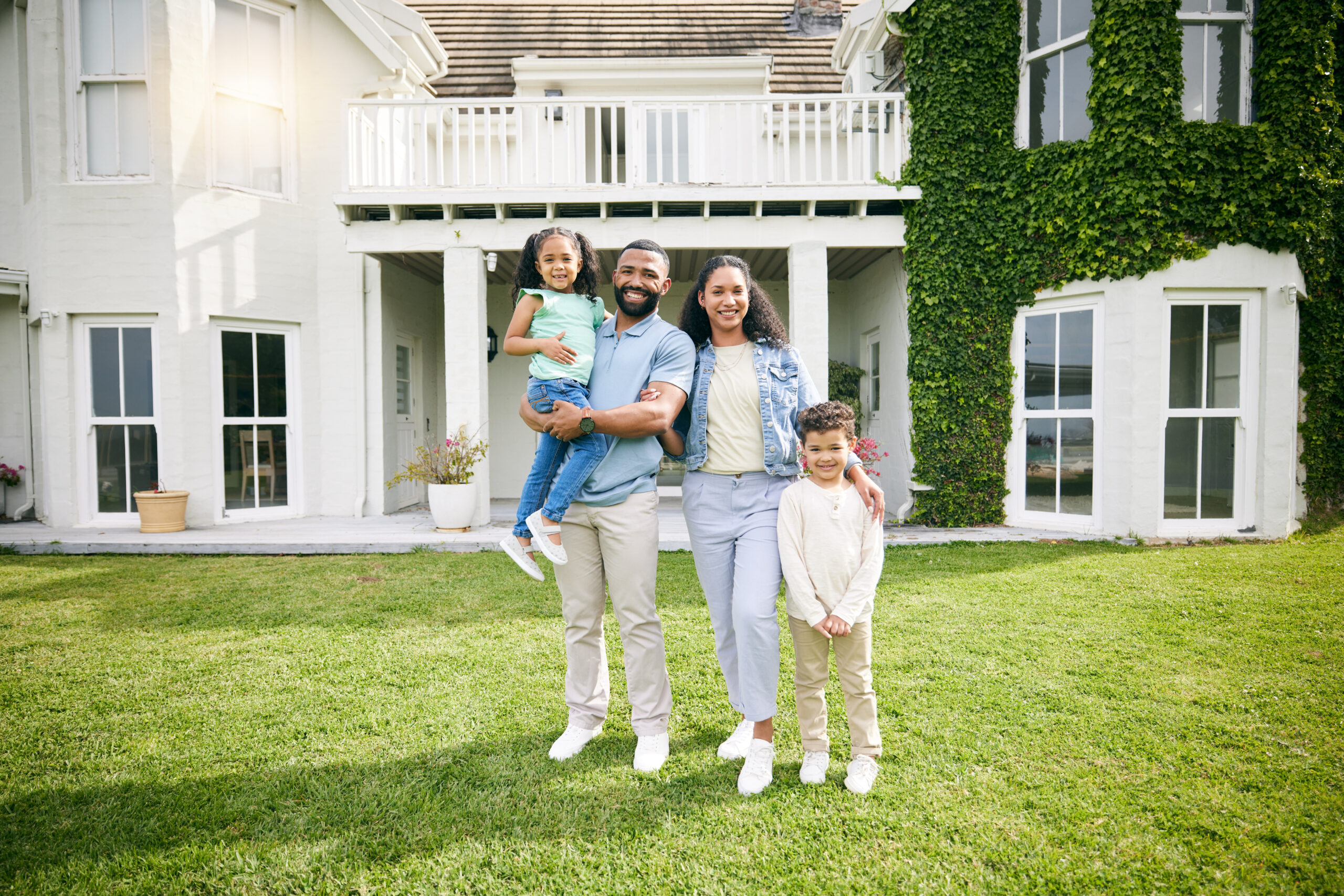Happy family in front of their refinanced home